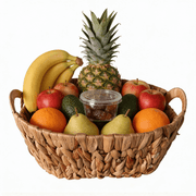 A beautifully arranged Energy Basket filled with fresh fruits including bananas, apples, oranges, and a pineapple.