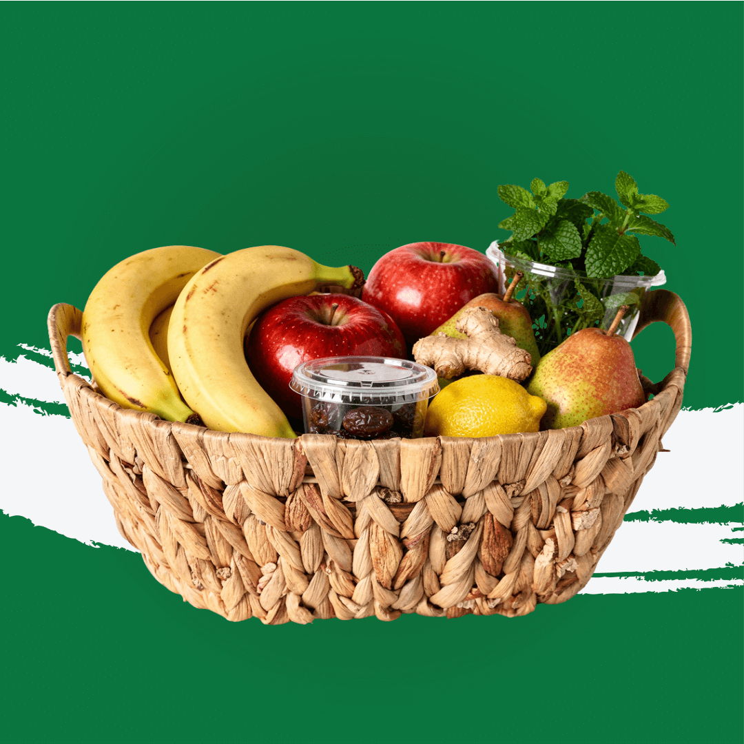 Wellness Basket filled with fresh fruits like bananas, apples, ginger, and mint leaves.